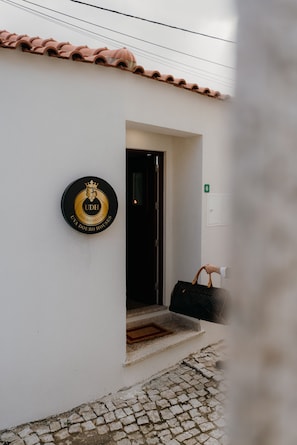 A building entrance with a sign indicating 'UDH DOURO VALLEY DOURO HOUSES' and a number '6' on the wall. - Casa Santana - Uva Douro Houses (Casais do Douro)