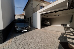 A car parked in a garage with a balcony above. - Casa de Xisto - Uva Douro Houses (Ervedosa do Douro)