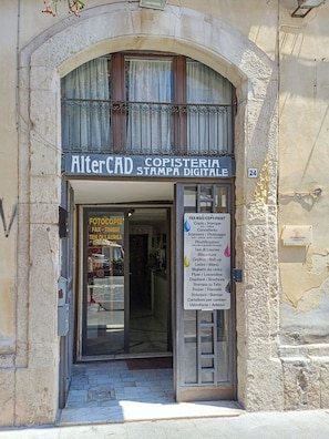 A storefront with a sign reading 'AlterCAD Copisteria Stampa Digitale' and a list of services like photocopying and printing. - Charming Suite with Original Frescoes – Exclusive Suite Just 5 Minutes from Ortigia. (Siracusa)