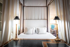 Ein ordentlich eingerichtetes Schlafzimmer mit einem großen Bett, zwei Nachttischlampen und einem dekorativen Teppich.