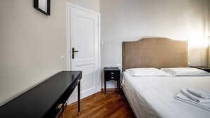 A bedroom with a bed, bedside table, nightstand, and a door. - Poggi 22 (Florence)