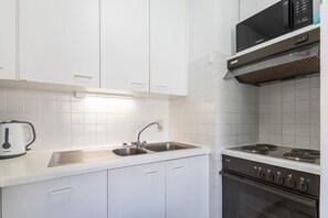 Eine moderne Küche mit weißen Schränken, einer Edelstahlspüle, einer Siemens-Mikrowelle und einem Siemens-Backofen.