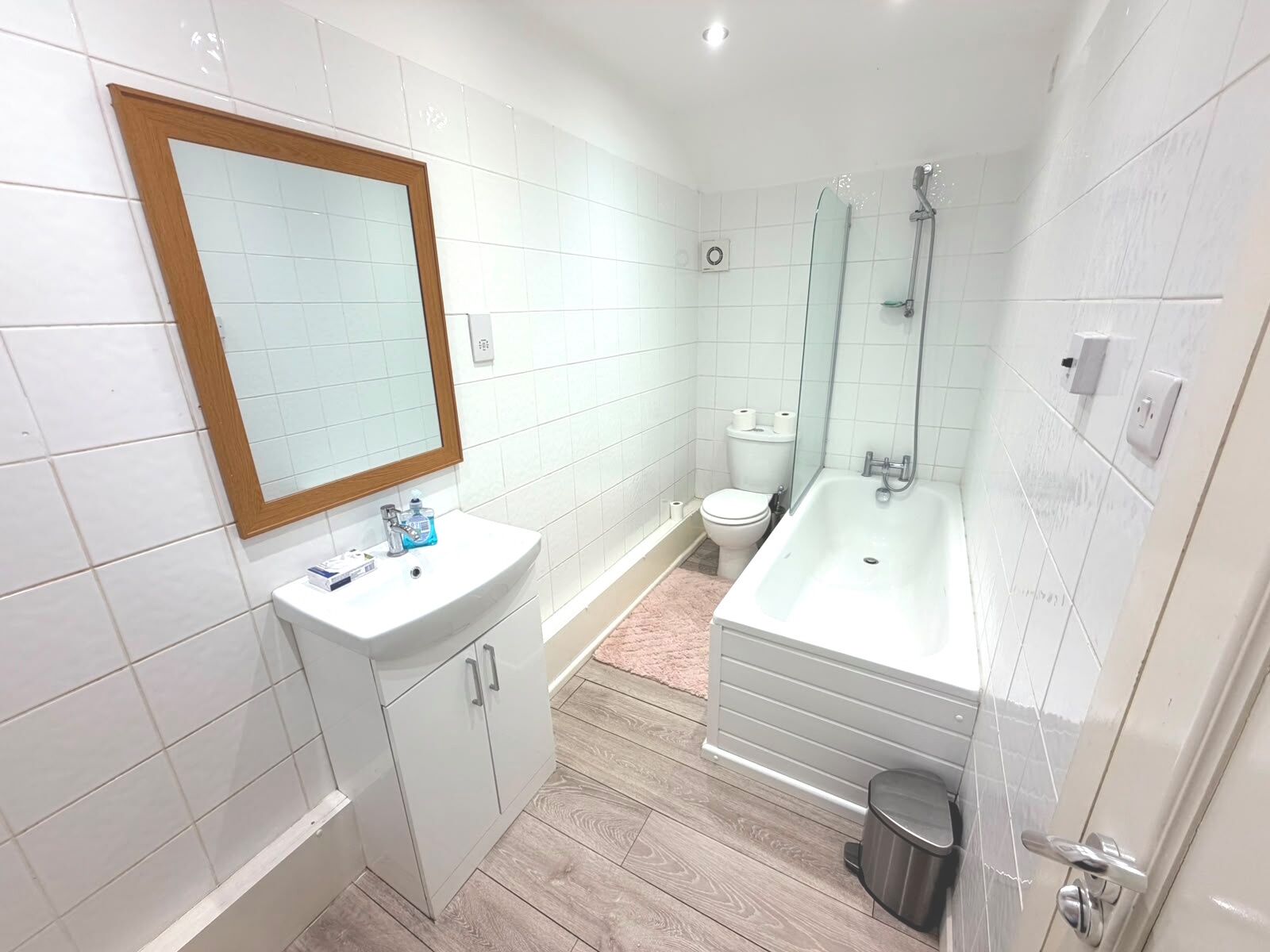 A modern bathroom with a white sink, toilet, and bathtub.