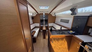 A compact galley with a sink, stove, and seating area. - Sun Odyssey 349 - Vitamar (Polesana)