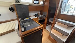 A compact galley with a sink, stove, and storage cabinets. - Sun Odyssey 349 - Vitamar (Polesana)