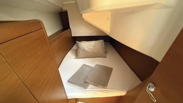 Ein gemütliches Häuschen mit einem Bett, einem kleinen Tisch und einem Stauschrank.