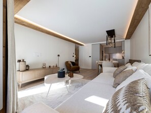 Ein modernes Wohnzimmer mit einer Couch, einem Couchtisch und einem Essbereich mit einem Stuhl und Tisch.