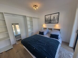 A bedroom with a large bed, a wardrobe, and a ceiling light. - Apartment with parking in Montgenèvre (Montgenèvre)