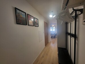 A hallway with framed pictures of Rome, Paris, and New York, a wooden floor, and a staircase with black railings. - Apartment with parking in Montgenèvre (Montgenèvre)