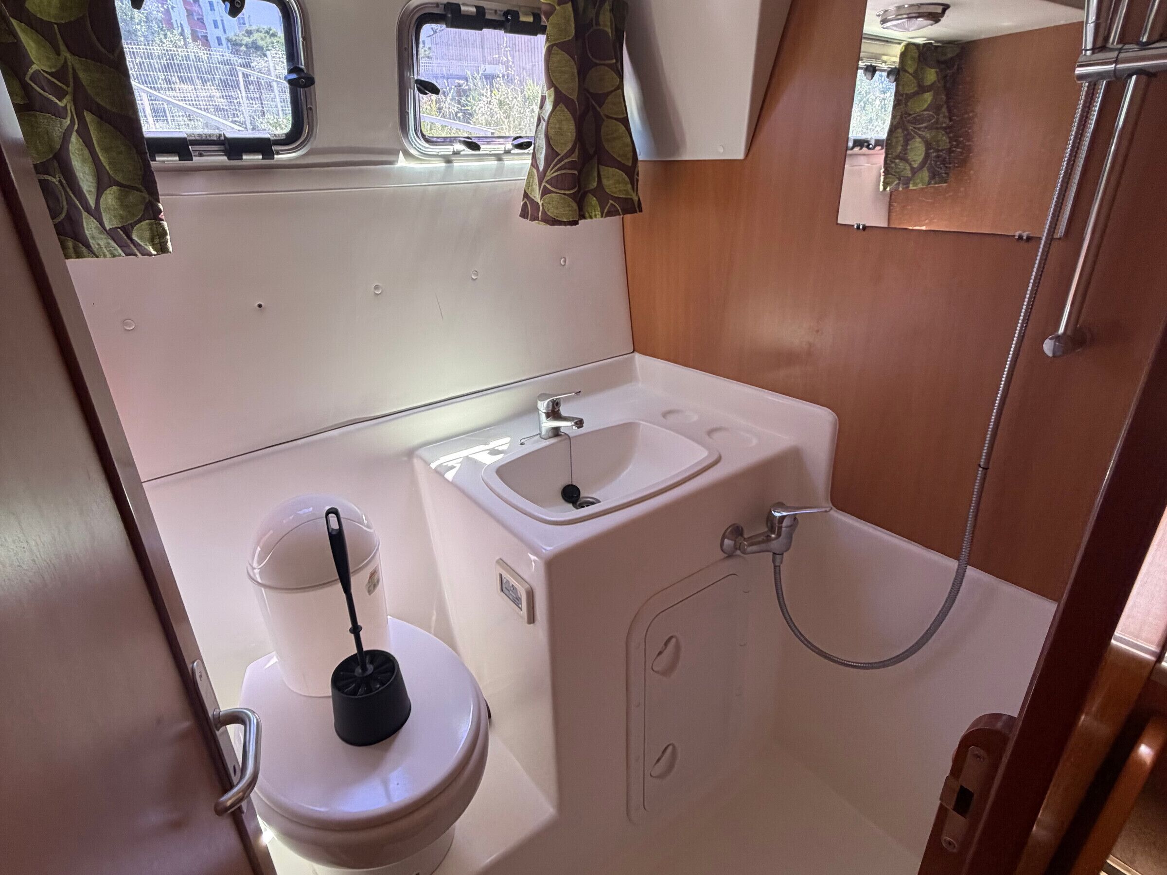 Une petite salle de bain comprenant des toilettes, un lavabo et une douche.