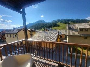 Uma varanda com vista para uma aldeia e montanhas.