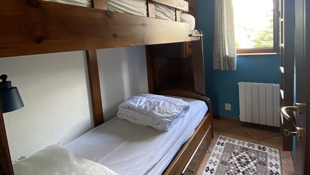 A bunk bed room with a window, a radiator, and a patterned rug. - Apartment in central Montgenèvre - 4 guests (Montgenèvre)