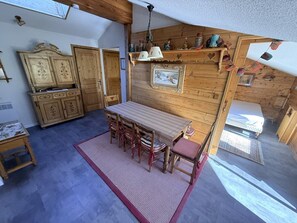 Un intérieur chaleureux en bois, comprenant un coin repas, un lit et une salle de bain.