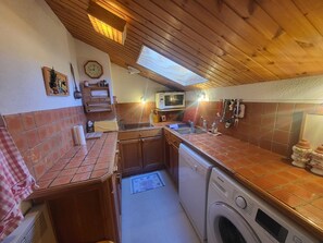 A compact kitchen with a washing machine, a microwave, and a sink. - 3-bedroom apartment on the slopes - 6 guests (Montgenèvre)