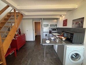 A compact kitchen with a washing machine, a microwave, and a toaster. - Cozy apartment with parking, sea view - 4 guests (Sanary-sur-Mer)