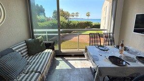 Ein Balkon mit Esstisch, Stühlen und einer Couch.