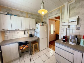 A kitchen with white cabinets, a refrigerator, a coffee maker, and a toaster. - Charming lodge in the heart of Touraine (Montlouis-sur-Loire)