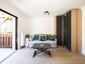 Un salon moderne avec un canapé, une table basse et une armoire.