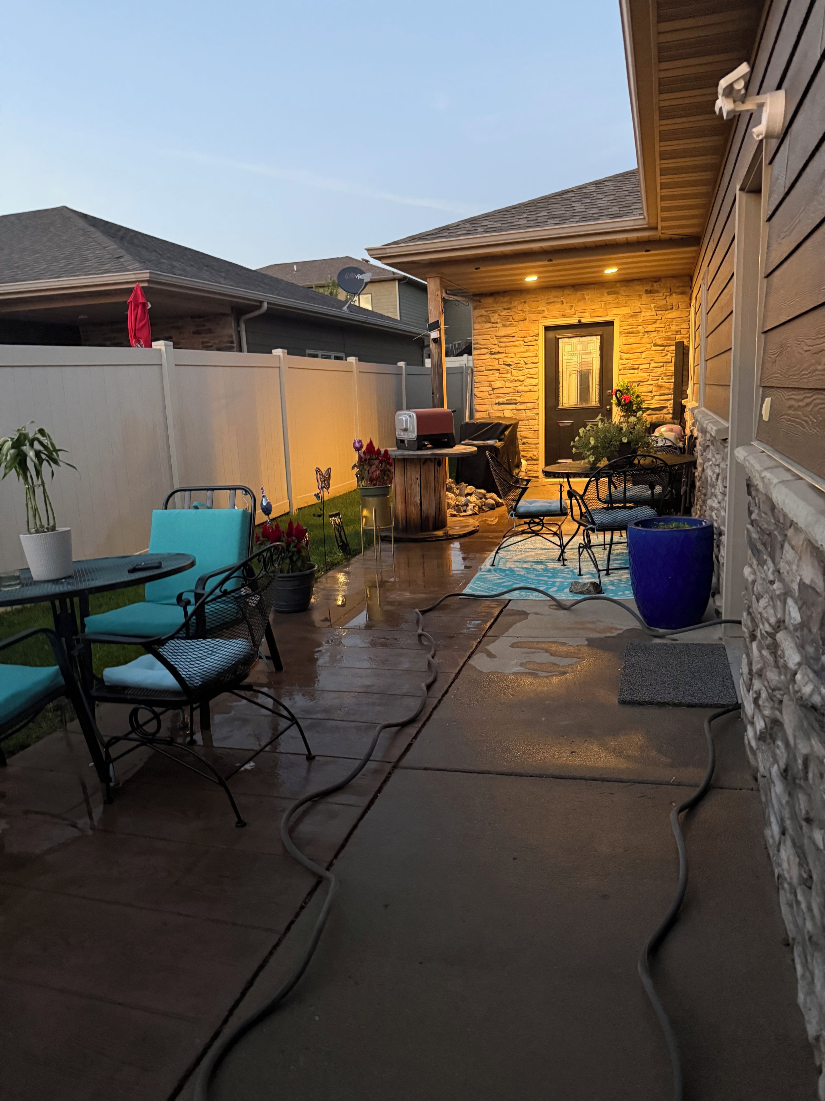 A patio with outdoor furniture, a barbecue grill, and a stone wall.