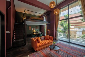 A modern interior with a bunk bed, a sofa, and a dining area. - Inpeng View Hotel (Vientiane)