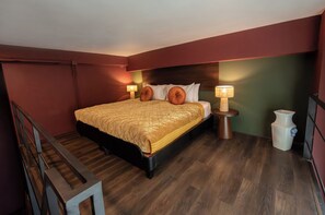 A bedroom with a bed, bedside lamps, a small table, and a trash bin. - Inpeng View Hotel (Vientiane)
