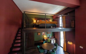 A multi-level room with a bed on the upper level and a dining area on the lower level. - Inpeng View Hotel (Vientiane)