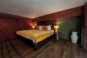 Habitación de hotel con una cama grande, dos lámparas de noche, una mesita de noche y un jarrón.