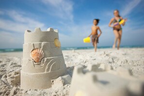 Un château de sable sur une plage, sous un ciel dégagé.