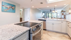 A modern kitchen with a central island, built-in oven, and stainless steel appliances. - 2B/2B WATERFRONT HARBOUR POINTE VACATION CONDO! WALK TO BEACH! RESORT POOL! (Fort Myers Beach)