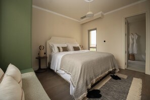 A bedroom with a bed, bedside table, and a view of the bathroom. - The Residence Suite, The Kodrian (Athens)