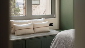 Ein Fensterplatz mit Kissen und einer Strickdecke.