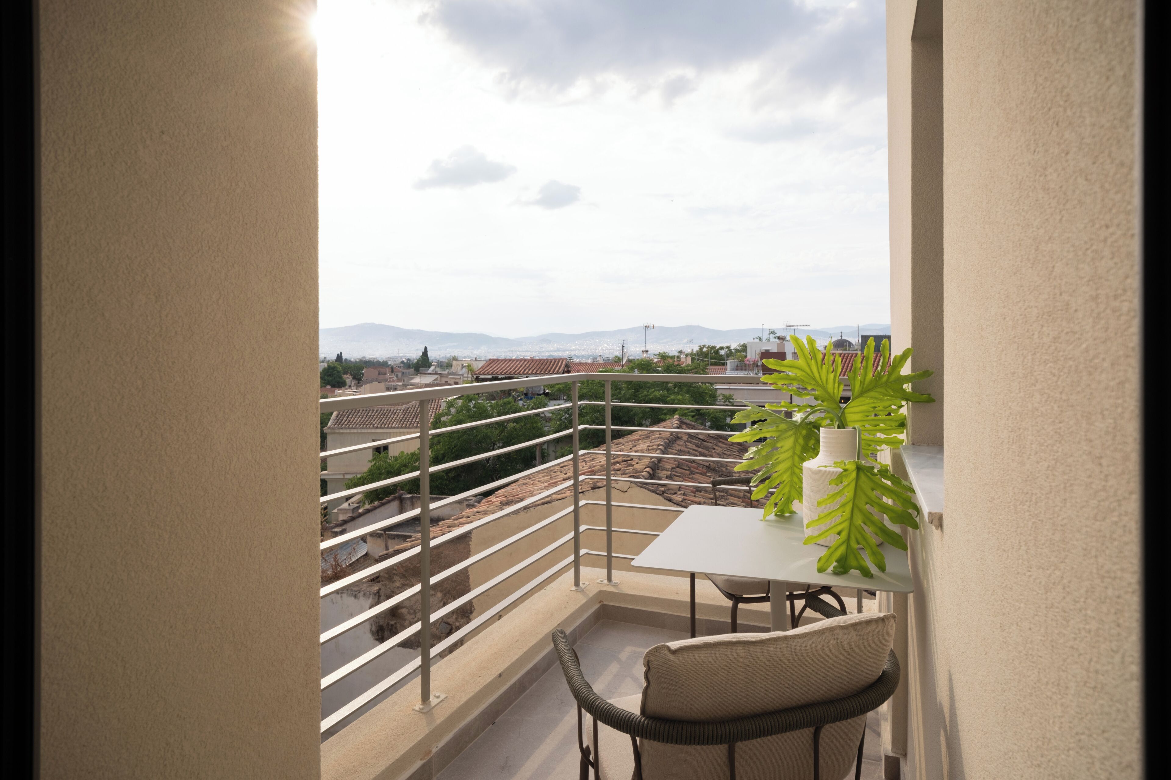 Ein Balkon mit Blick auf die Stadt, ein Tisch und ein Stuhl.