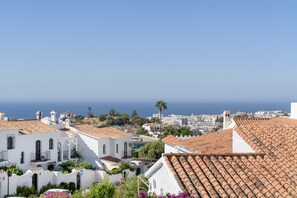 A coastal town with white buildings and terracotta roofs, overlooking the sea. - Jazmín 1A – Sea View Holiday Home in Capistrano Village (Nerja)