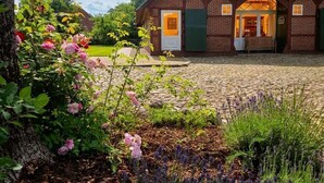 A traditional building with a thatched roof, a brick facade, and a welcoming entrance. - FH Luhe-Hof - Historisches Reetdachanwesen (Winsen (Luhe))