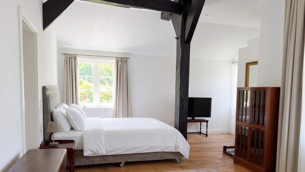 A bedroom with a bed, a desk, a TV, and a cabinet. - FH Luhe-Hof - Historisches Reetdachanwesen (Winsen (Luhe))