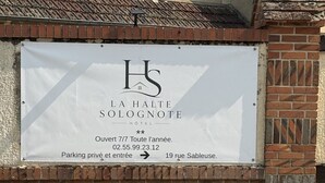 A sign for La Halte Soignonne Hotel, indicating it is open year-round, with private parking and entry. - La Halte Solognote (Brinon-sur-Sauldre)