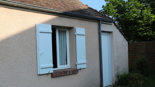 A building with a single window and a door, both with white shutters, and a small brick ledge below the window. - La Halte Solognote (Brinon-sur-Sauldre)