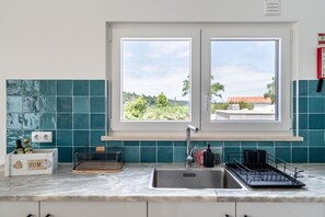 Eine Küche mit Fenster, Spüle und Arbeitsplatte.