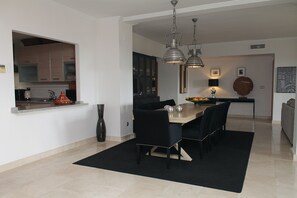 A modern dining area with a table, chairs, and pendant lights. - Garden Apartment. Golf by the Sea in Estepona (Estepona)