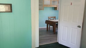 A hallway with a teal wall, a white door with the number 3, and a wooden chair in the background. - Cozy 1BR Fort Myers Getaway – Minutes to Downtown! (Fort Myers)
