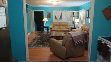 Una sala de estar con un sofá, un sillón reclinable, una mesa de centro y una alfombra.