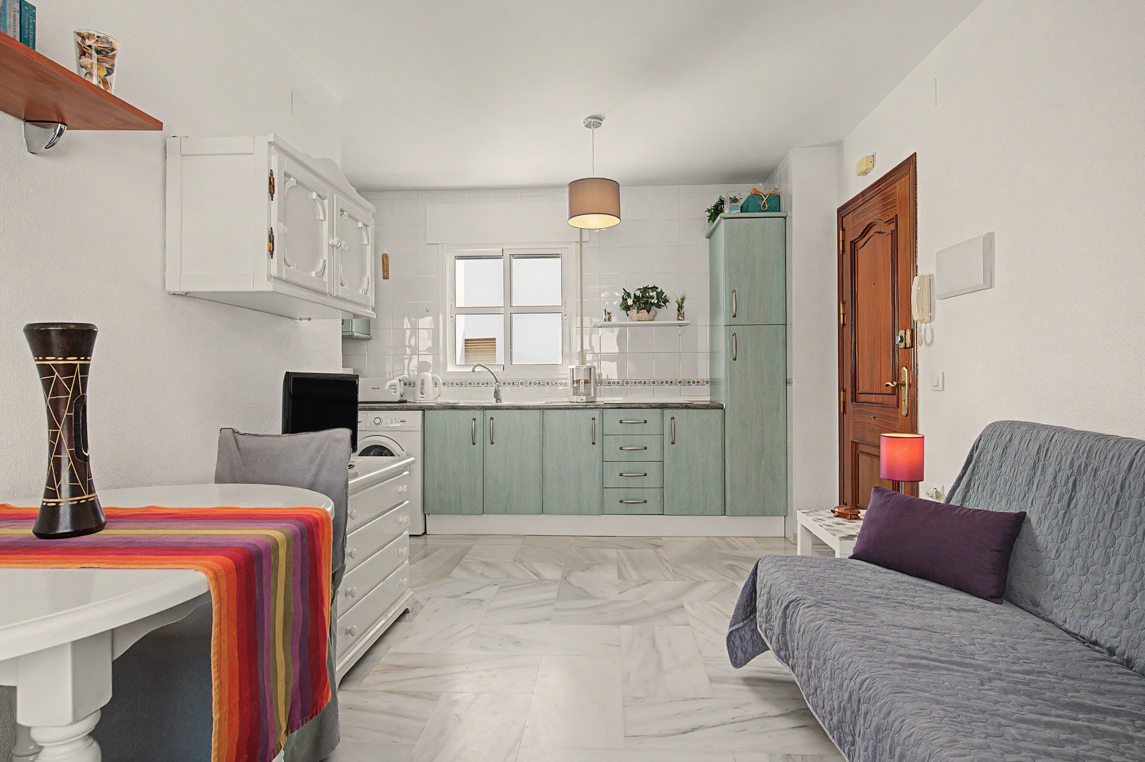A compact living space with a kitchen, a dining area, and a seating area.