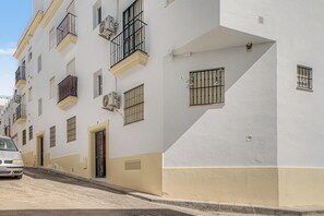 A multi-story building with balconies, air conditioning units, and barred windows. - Apartment 'Annett - Families Only' with Wi-Fi (Conil de la Frontera)