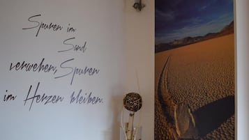 Ein Zimmer mit einer Wand, die eine Wüstenlandschaft zeigt und eine deutsche Schrift trägt.