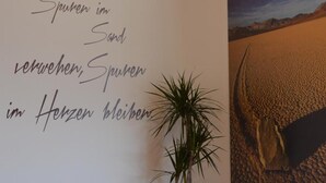 A room with a large wall mural depicting a desert landscape, a potted plant, and a rug on the floor. - Apartment 'Residence Ladurn Erde' with Mountain View, Private Terrace and Wi-Fi (Tirol)