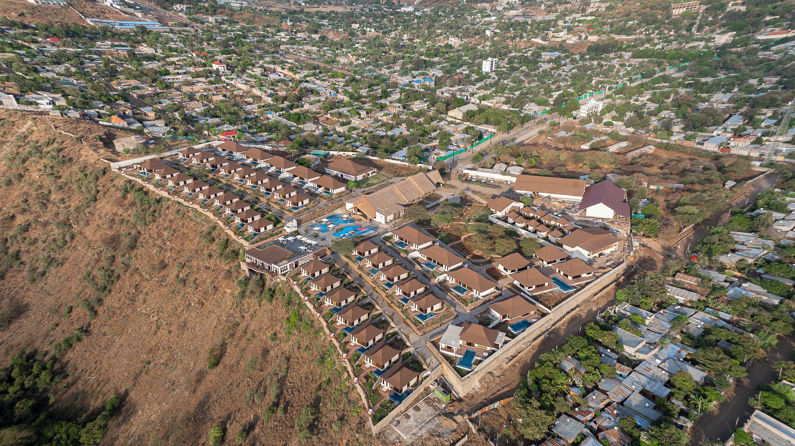 Zona residencial con varias casas y un edificio grande con piscina.