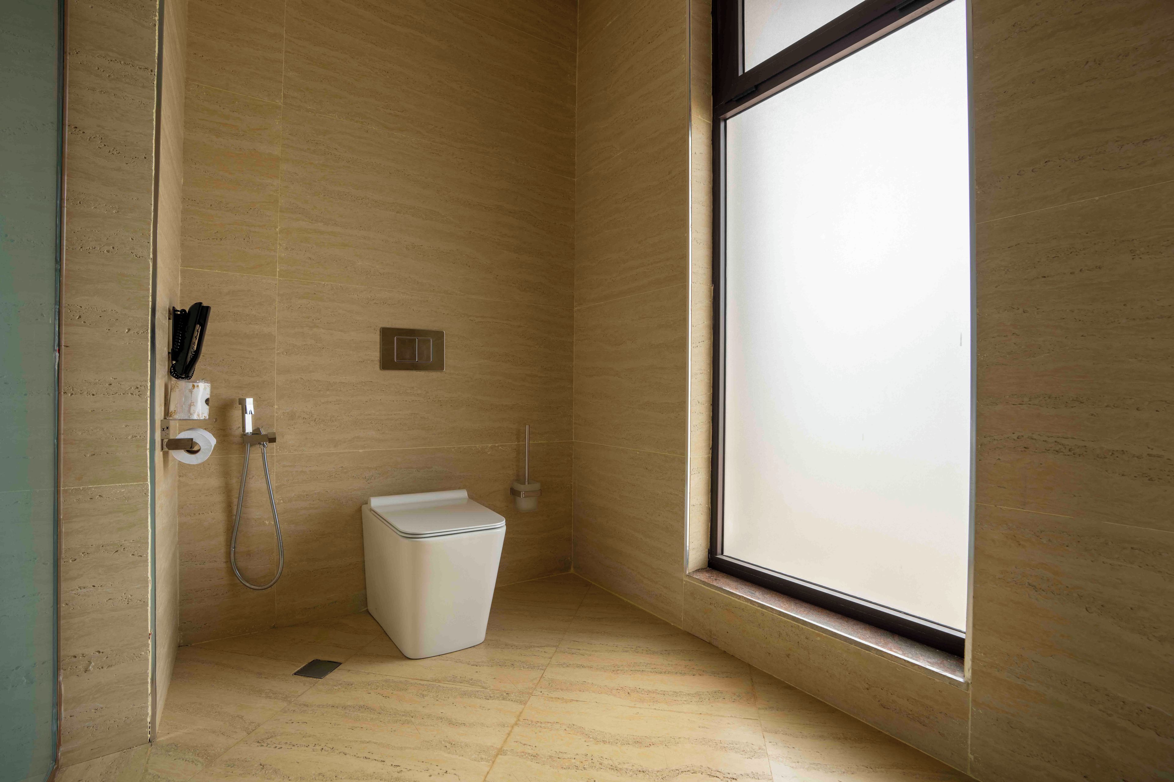 Un baño pequeño y moderno con inodoro, ducha y ventana.