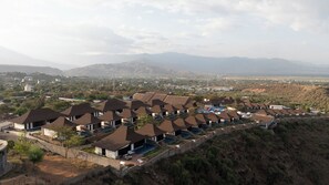 A resort with multiple bungalow-style buildings, each with a private pool and a view of the surrounding landscape.