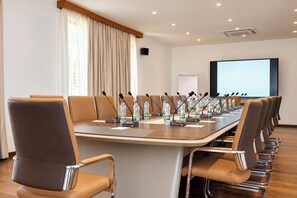 A conference room with a long table, multiple chairs, microphones, and water bottles. - Kuriftu Resort & Spa Arba Minch  (Arba Minch)