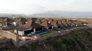 A resort with multiple bungalow-style buildings, each featuring a private pool and outdoor seating area.